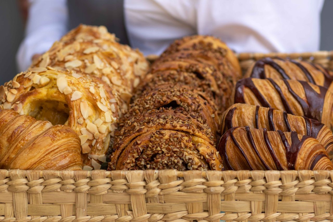 our-value Close-up view of a basket filled with assorted French pastries, perfect for bakery lovers.