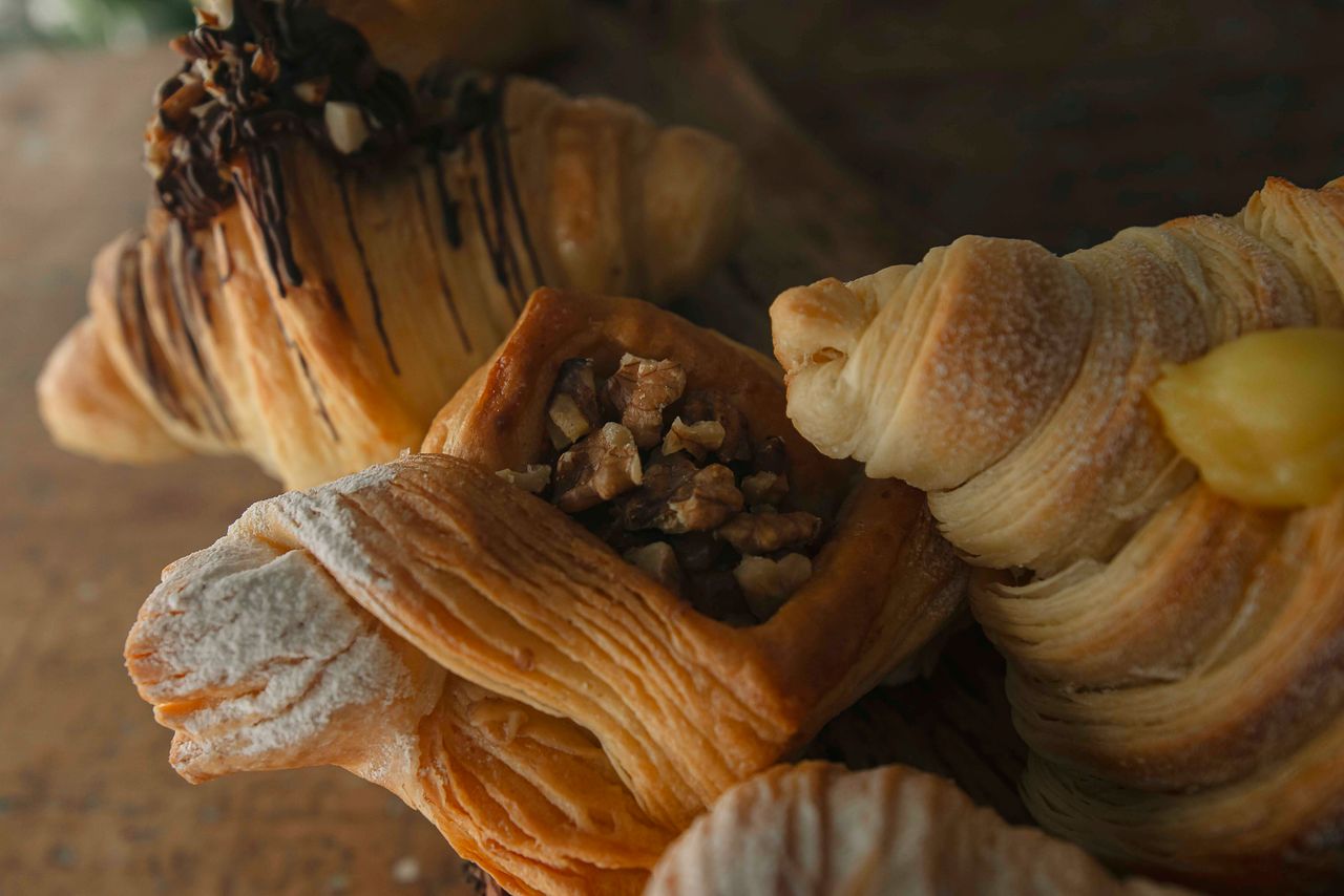 about-02 Delicious assortment of flaky pastries including croissants and nut-filled danish.