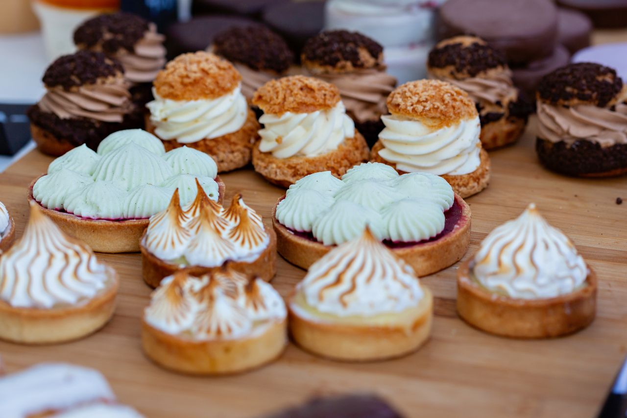about-01 Delicious cream pastries and tarts beautifully arranged, showcasing a variety of textures and flavors.